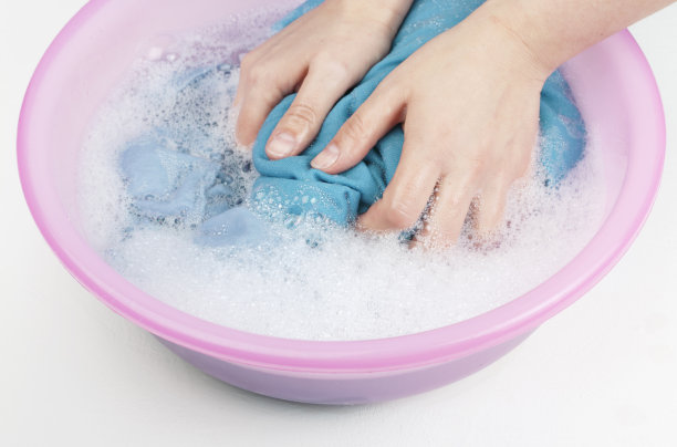 女人们用手在盆里洗白蓝衣服图片下载