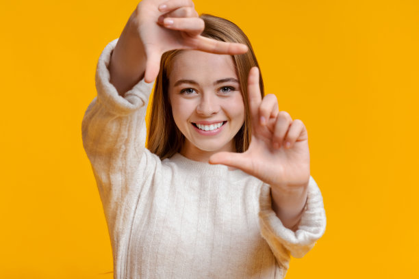微笑的女孩用手指框着脸，假装在拍照图片下载