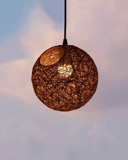 夕阳下的天空上挂着一盏灯的编织帘子图片下载
