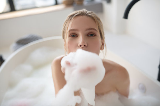 蓝眼睛的女人在洗澡时手里拿着泡沫图片下载