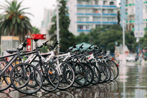 一排排停放着不同的自行车。自行车停在停车场上图片下载