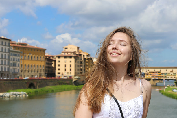 快乐的女人在亚诺河和建筑背景在佛罗伦萨，意大利图片下载