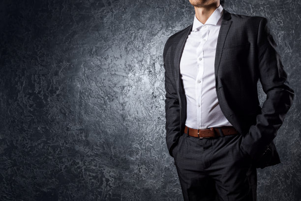 穿西装的人靠在水泥墙上图片下载