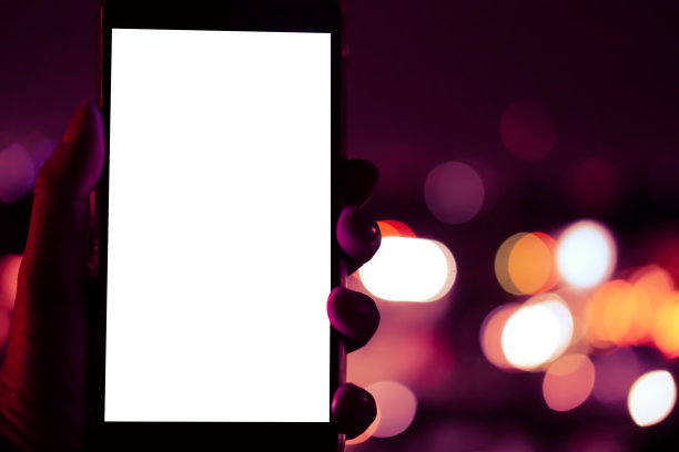 手持移动智能手机与散景夜灯图片下载
