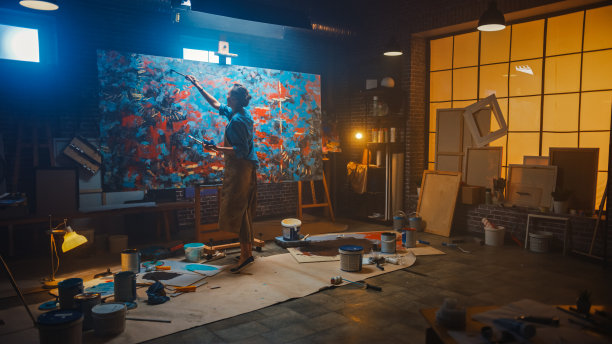 才华横溢的女艺术家在现代抽象油画，用画笔的粗线条手势。黑暗创意工作室大图片站在画架上照明，工具无处不在图片下载