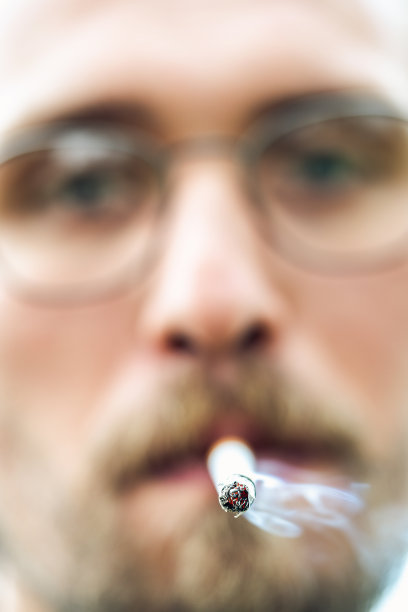 一个年轻男子吸烟的特写照片图片下载