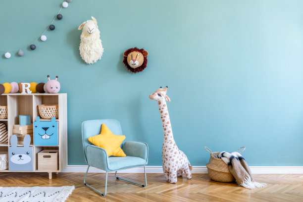 斯堪的纳维亚保育室，木制橱柜，薄荷扶手椅，天然泰迪熊和毛绒动物玩具。可爱的现代室内游戏室与桉树墙，婴儿配件和玩具。副本的空间。图片下载