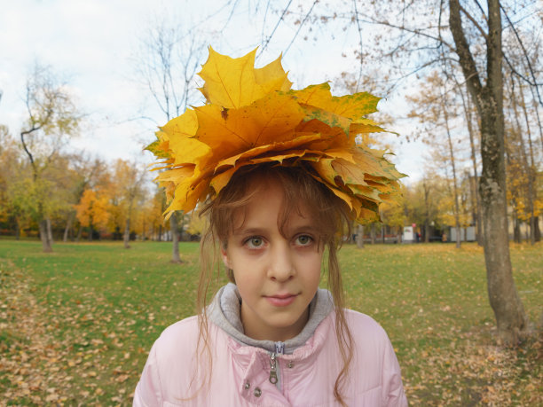 可爱的女孩戴着金色的秋叶花环图片下载