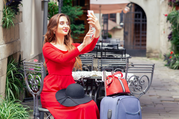 时尚的女旅行者正在自拍。图片下载