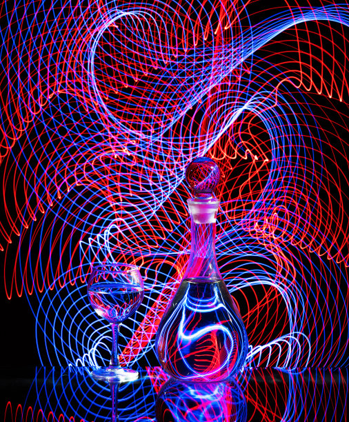 在一个葡萄酒杯和а酒壶后面的光画图片下载