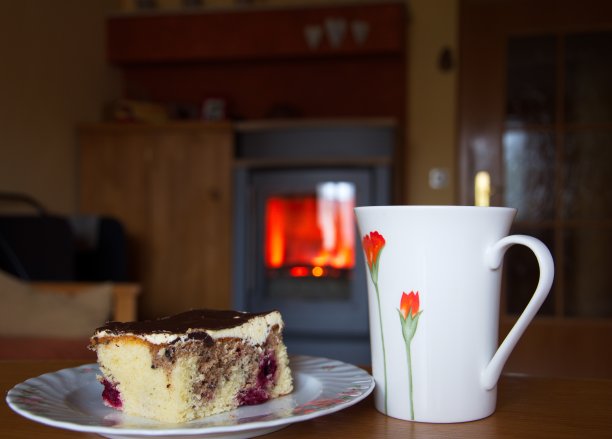 杯子和蛋糕放在壁炉前图片下载