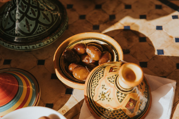 典型的陶瓷菜肴和塔吉尼在一个摩洛哥风格的桌子。图片下载