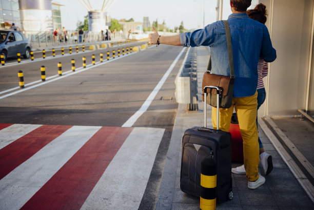 夫妇搭便车与行李在道路库存照片图片下载