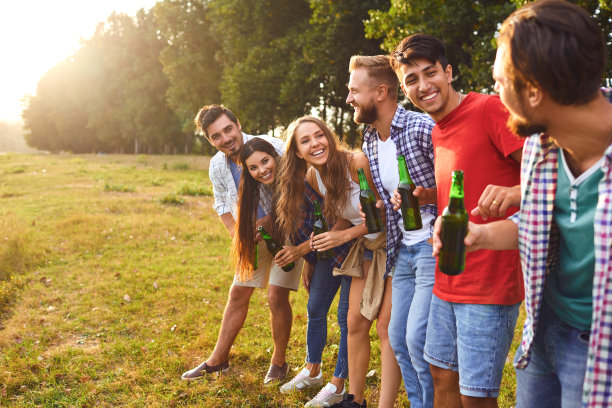 年轻人在野餐时喝酒碰杯素材图片