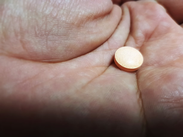 手上有选择焦点的橙色药物药丸图片下载