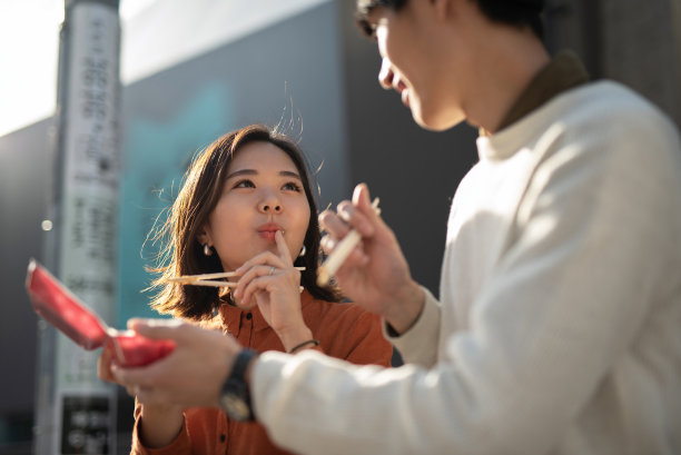 一对年轻夫妇在街上吃着外卖图片下载