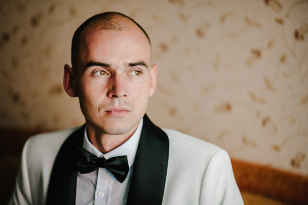 穿西装打领结的男人。早上准备在家梳妆。一个男人的时尚照片。图片下载