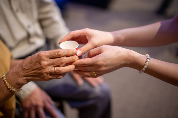 新婚夫妇在中国传统茶道上给老人斟茶图片下载