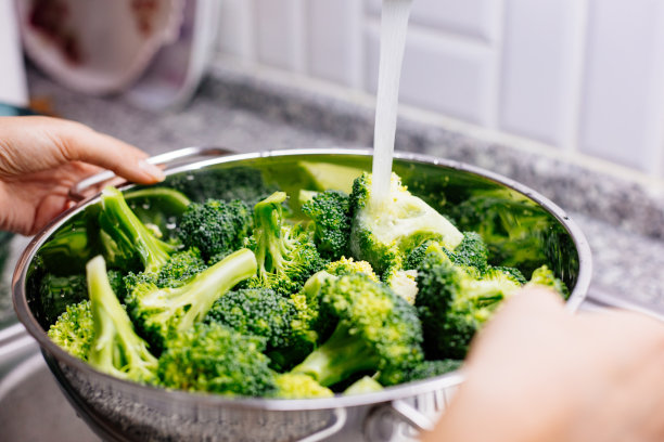 在厨房水槽里洗花椰菜的女人图片下载