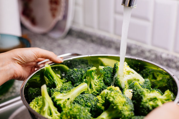 在厨房水槽里洗花椰菜的女人图片下载
