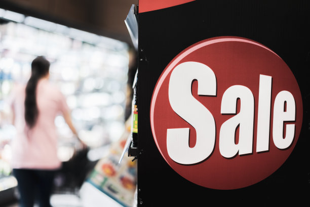 货架上的销售标签，模糊超市和女性背景的网上销售和购物概念，电子商务，商业概念。图片下载