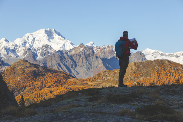男性独自旅行者在山上查看路线地图图片下载