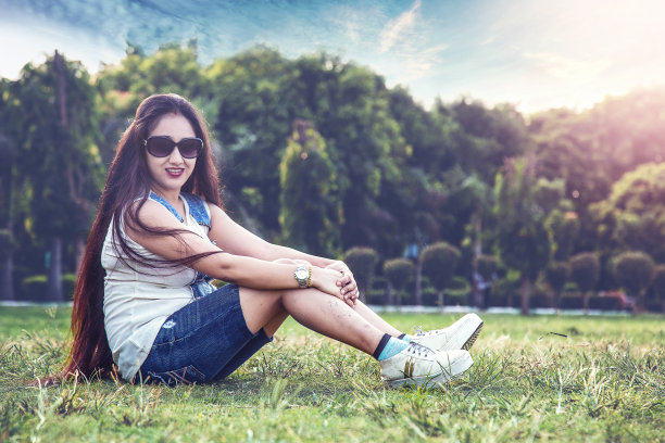 坐在草地上的年轻漂亮女人图片下载