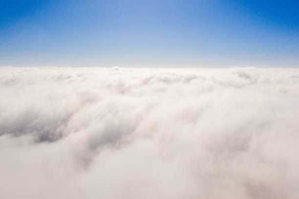 从飞机窗口看到的云层上的日出。图片下载