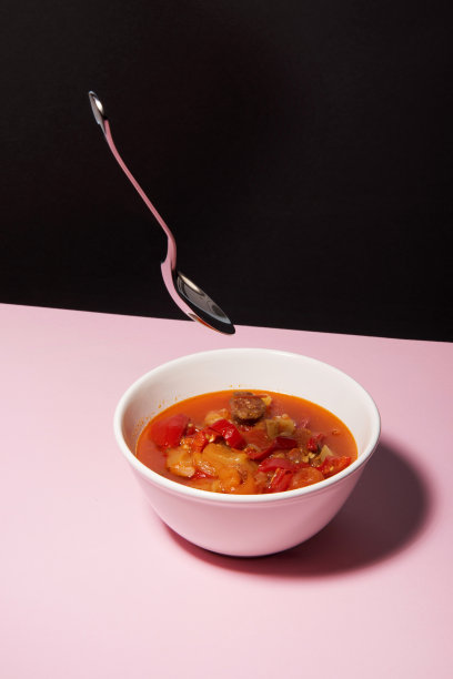 端上红牛肉汤在粉红色的表面和黑色的背景。图片下载