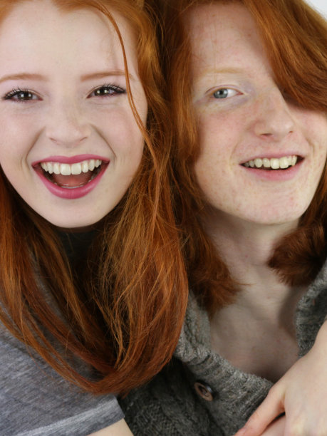 照片中，14 / 15岁的红头发女孩，皮肤苍白，脸上有雀斑，坐在卧室里，旁边是她16 / 17岁的姜黄色头发的哥哥，看着镜头微笑，四处嬉戏，男孩被妹妹拥抱，而她对着镜头大笑图片下载