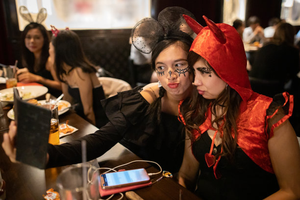 亚洲妇女在万圣节服装拍照的万圣节派对图片下载
