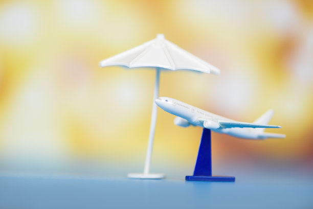 保险旅游概念-空中旅行和白色伞上飞机飞行模糊的背景图片下载