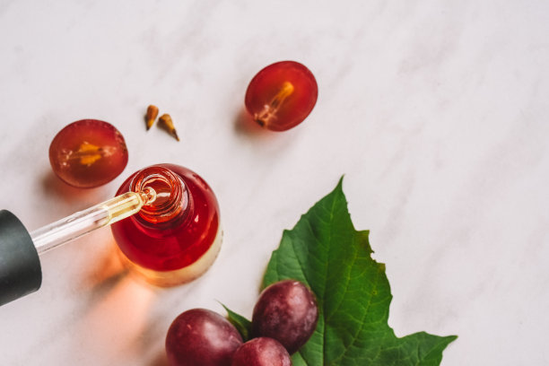 葡萄籽油。移液器，含油脂，血清和一瓶特写。有选择性的重点图片下载