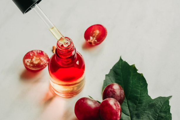 葡萄籽油。移液器，含油脂，血清和一瓶特写。有选择性的重点图片下载