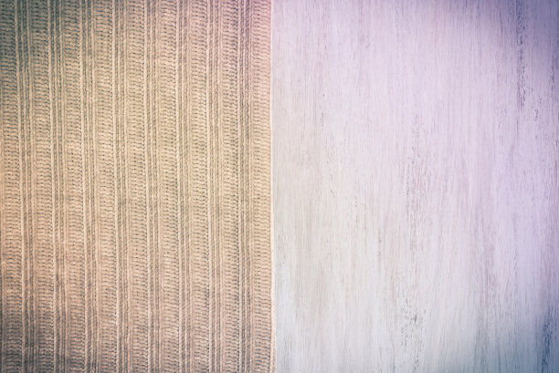 针织米色柔软的织物上浅色油漆木板。背景，原始的紫色色调的照片。图片下载