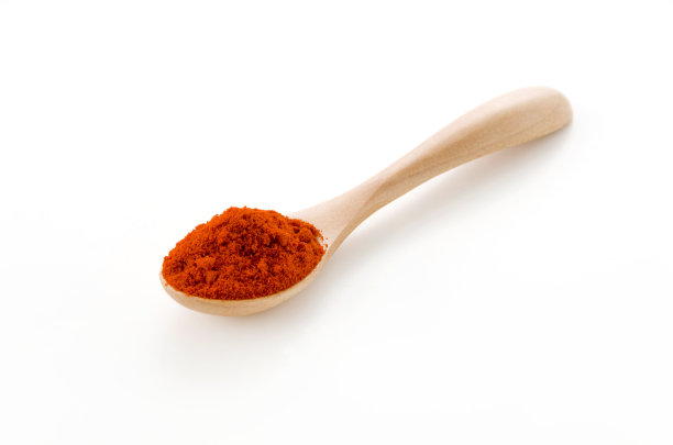 木勺里放辣椒粉，白色背景图片下载