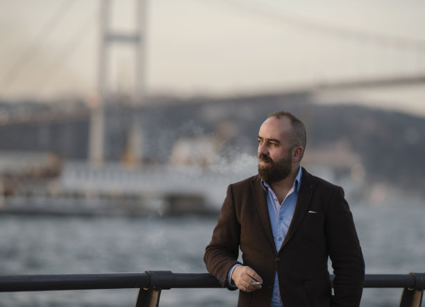 伊斯坦布尔博斯普鲁斯，一名男子在室外吸烟图片下载