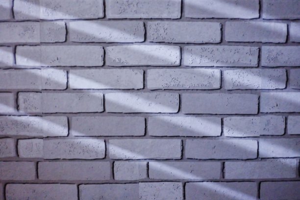 一组阴影光线照射在白墙砖表面，形成背景纹理图片下载