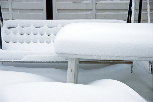 一层厚厚的白毯子覆盖着露台上的花园家具图片下载