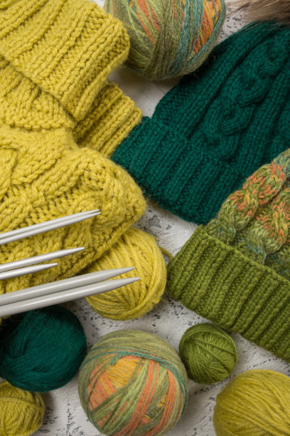 手工针织品，用线球和针在一个轻的背景上，作为图案，纹理和爱好的背景。从以上观点。图片下载