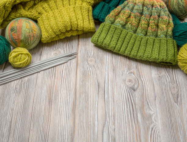 手工针织品，用线球和针在一个轻的背景上，作为图案，纹理和爱好的背景。从以上观点。图片下载