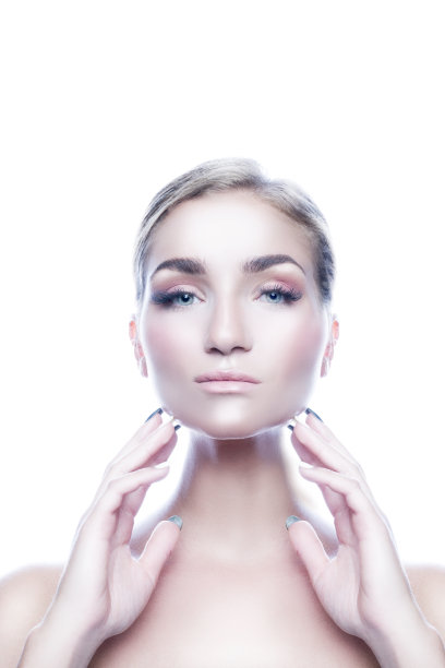 美丽的女人肖像与健康的皮肤面部涂抹霜与手图片下载