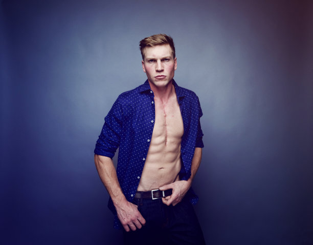 一人/一人只/腰部以上的20-29岁英俊的人白人男性/年轻男子脱衣舞在前面在紫色的背景/彩色的背景穿着钮扣衬衫/完全解开谁是脱衣图片下载