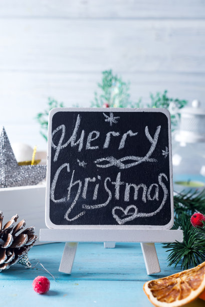 黑色黑板上写着“圣诞快乐!”蓝色背景上的圣诞装饰图片下载