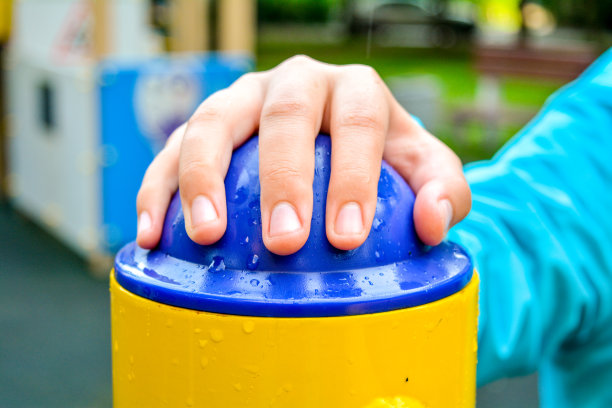 儿童手握按钮儿童运动器材在操场上图片下载