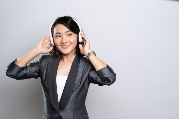 快乐的女人戴着耳机，在白色的背景下听音乐图片下载