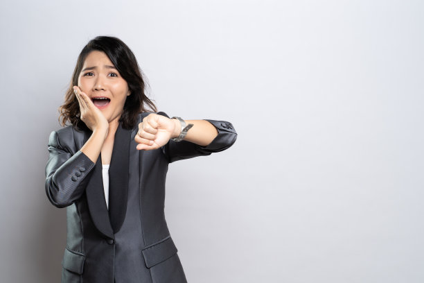 震惊的女人手握腕表孤立在一个白色的背景图片下载