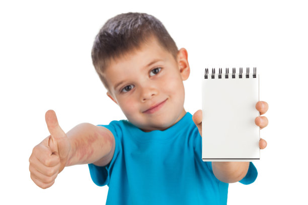 5岁的幼稚园男孩展示笔记本和拇指ok，孤立在白色背景上图片下载