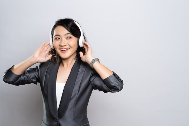 快乐的女人戴着耳机，在白色的背景下听音乐图片下载