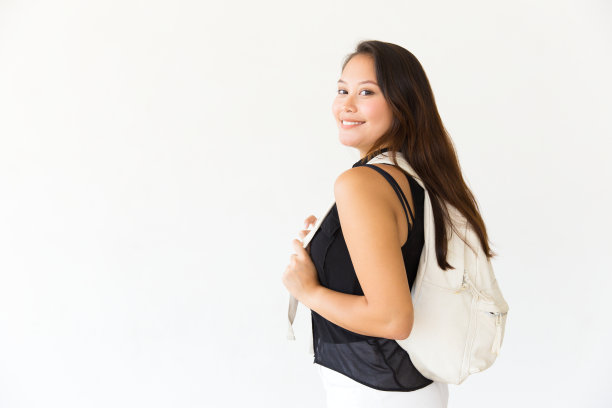 欢乐的学生女孩背双肩包的工作室肖像图片下载
